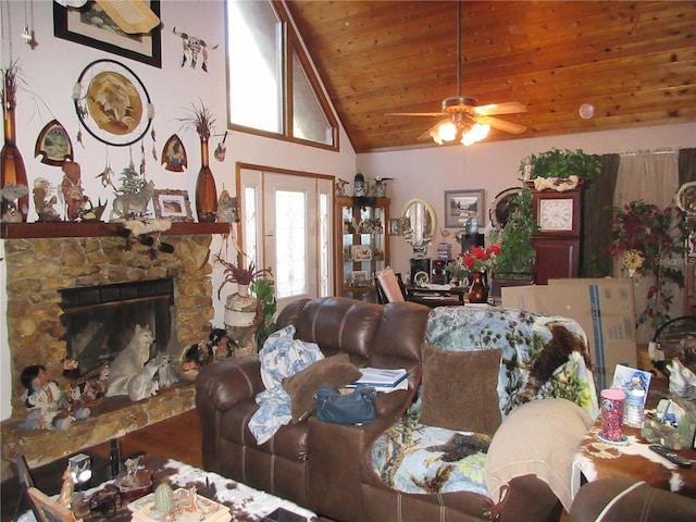 living room featuring wood ceiling, a stone fireplace, high vaulted ceiling, and ceiling fan