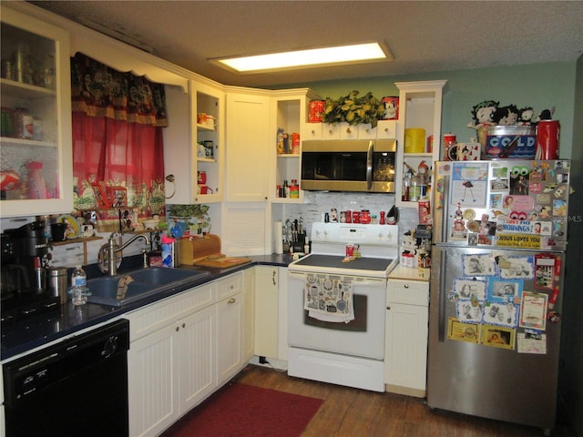 kitchen featuring stainless steel appliances, white cabinetry, sink, and dark hardwood / wood-style flooring