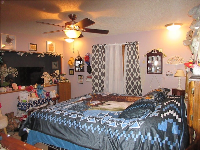 bedroom with ceiling fan and a textured ceiling