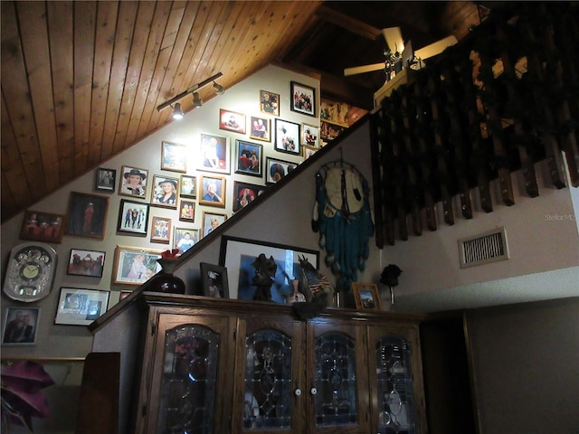 stairway with wood ceiling, lofted ceiling, and rail lighting