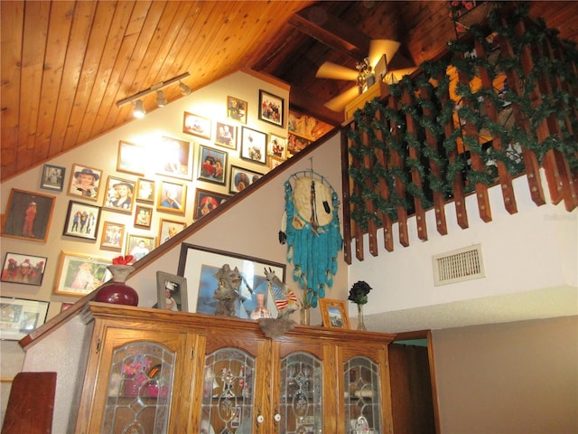 stairway with high vaulted ceiling, track lighting, wooden ceiling, and ceiling fan