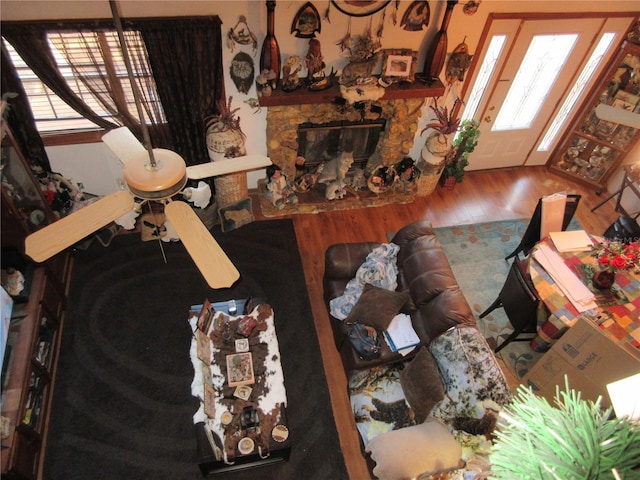 living room featuring wood-type flooring and a stone fireplace