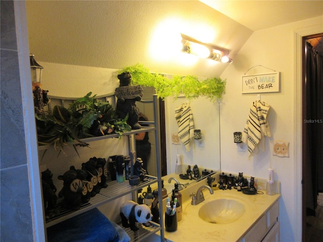 bathroom featuring vaulted ceiling and vanity