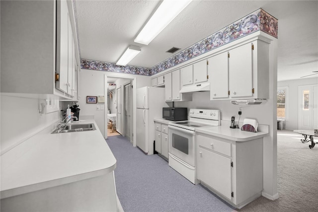 kitchen featuring sink, white appliances, white cabinets, a textured ceiling, and light colored carpet