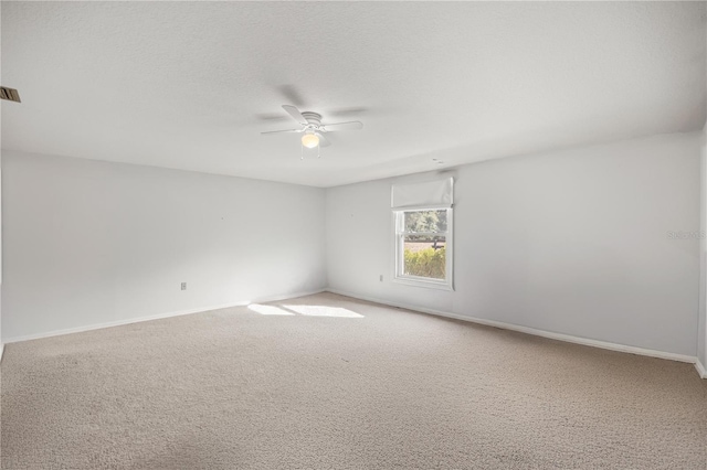 carpeted spare room with ceiling fan and a textured ceiling