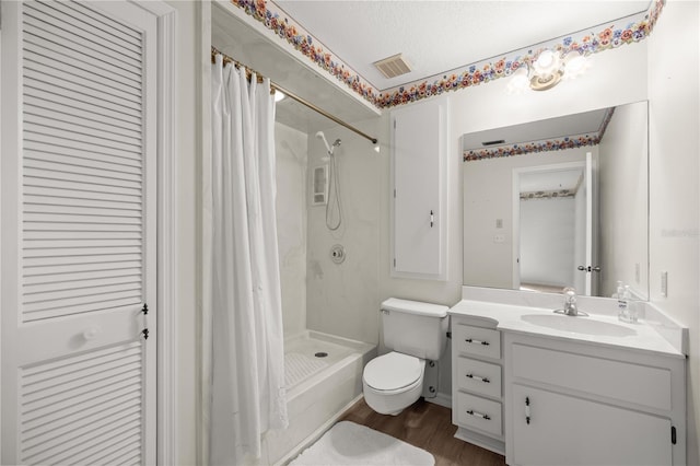 bathroom with toilet, a shower with curtain, wood-type flooring, a textured ceiling, and vanity