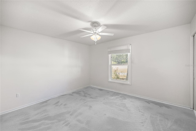 carpeted spare room featuring ceiling fan and a textured ceiling