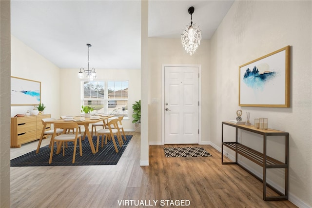 foyer featuring a notable chandelier, baseboards, and wood finished floors