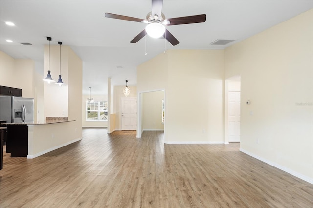 unfurnished living room featuring baseboards, visible vents, high vaulted ceiling, light wood finished floors, and ceiling fan