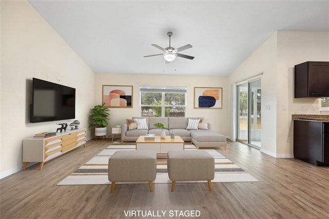 living area featuring light wood-type flooring, plenty of natural light, and lofted ceiling