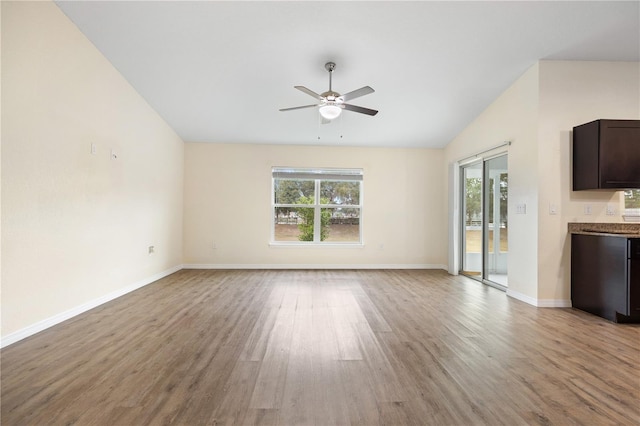 unfurnished living room featuring light wood-type flooring, plenty of natural light, ceiling fan, and vaulted ceiling