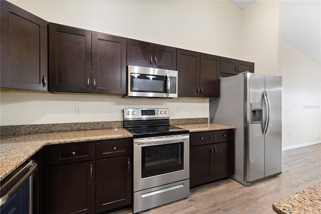 kitchen with dark brown cabinets, light wood finished floors, and stainless steel appliances