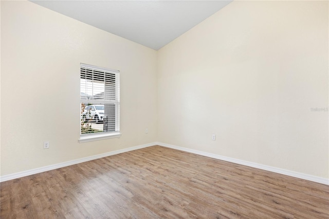 unfurnished room with baseboards and wood finished floors