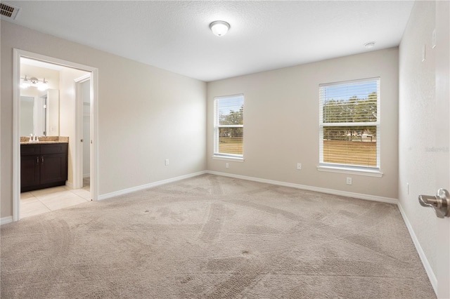 empty room with visible vents, light colored carpet, and baseboards