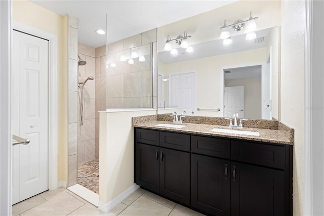 bathroom featuring a sink, walk in shower, double vanity, and tile patterned flooring