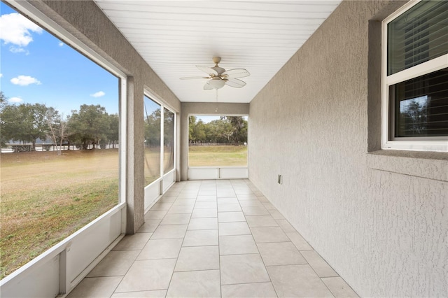 unfurnished sunroom with a ceiling fan