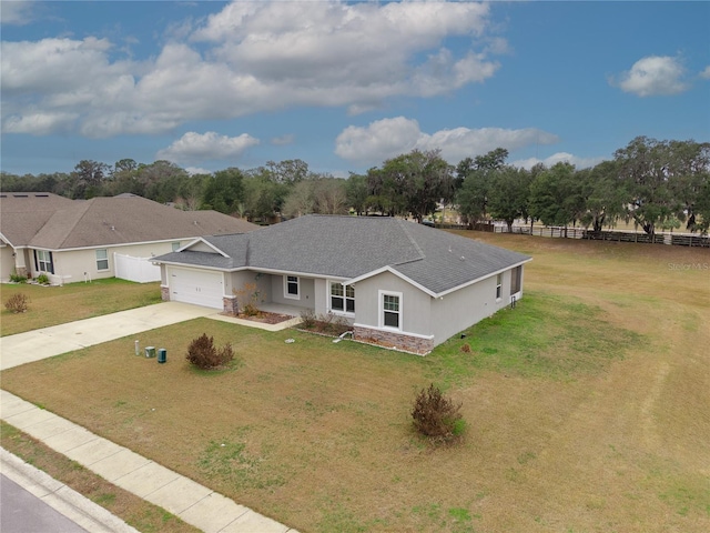 view of front facade with a front yard, concrete driveway, a garage, and fence