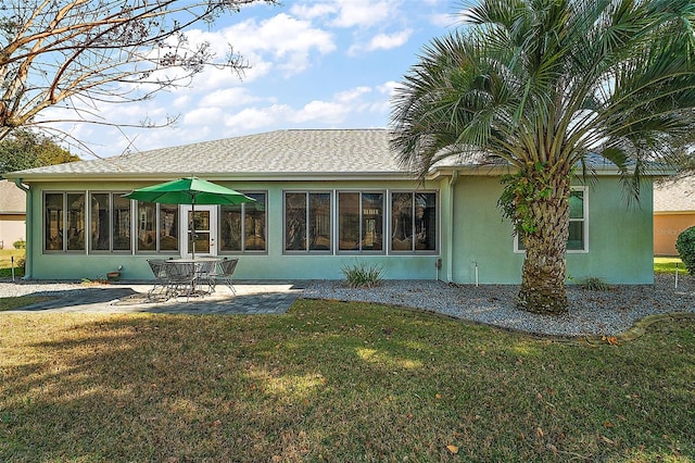 rear view of house featuring a yard and a patio area