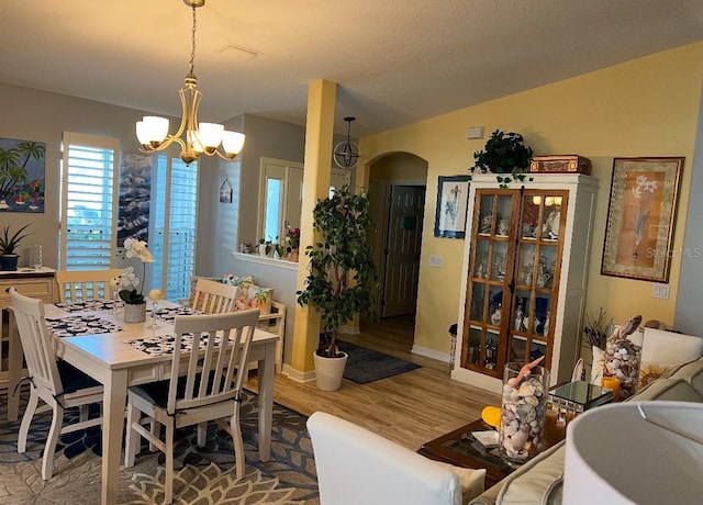 dining space with lofted ceiling, a chandelier, and hardwood / wood-style floors