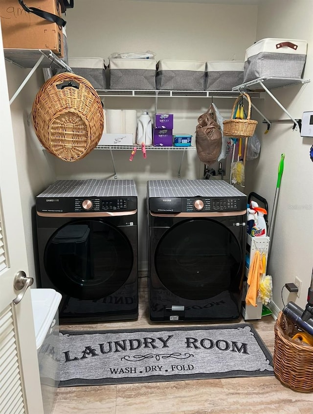 washroom featuring washing machine and dryer and wood-type flooring