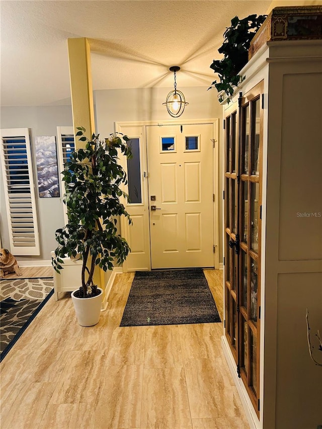 entryway featuring a textured ceiling and wood finished floors