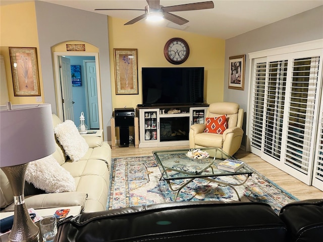 living area featuring lofted ceiling, wood finished floors, and a ceiling fan