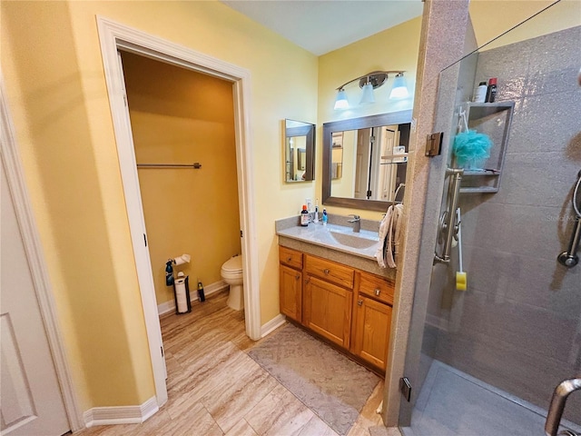 full bath featuring baseboards, toilet, a shower stall, and vanity