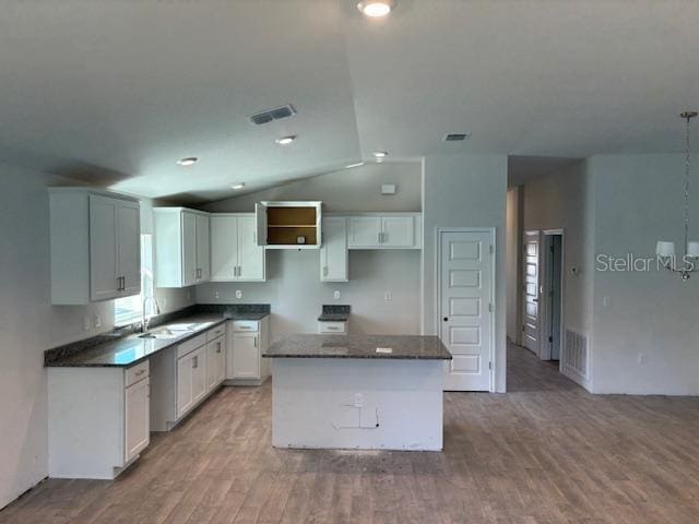 kitchen featuring sink, hardwood / wood-style flooring, white cabinets, and a kitchen island