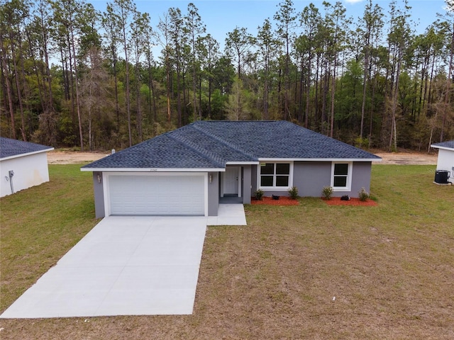 ranch-style house featuring driveway, a shingled roof, an attached garage, a front yard, and stucco siding