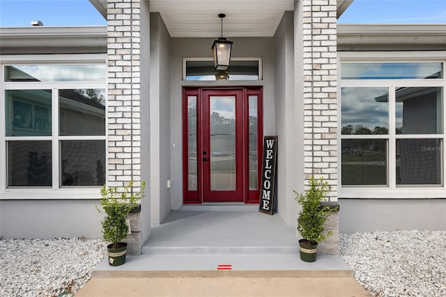 entrance to property with brick siding and stucco siding