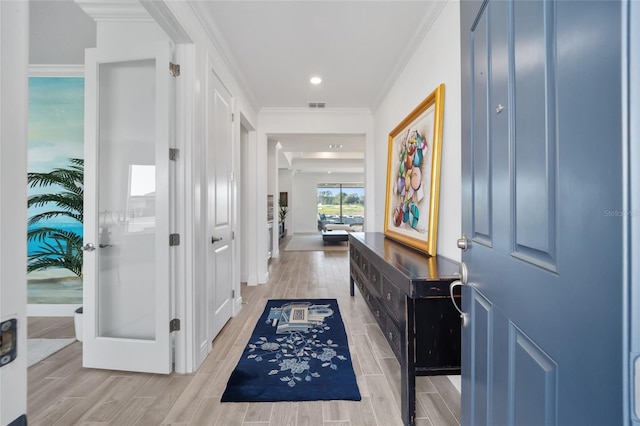 entrance foyer with wood tiled floor, visible vents, and crown molding