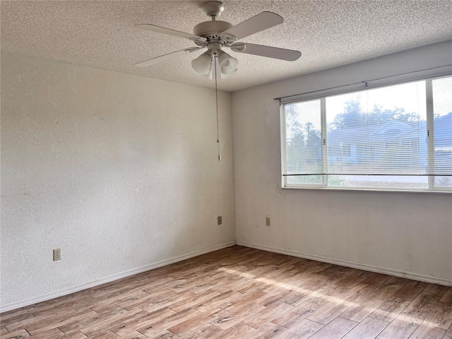 unfurnished room featuring ceiling fan, plenty of natural light, a textured ceiling, and light hardwood / wood-style flooring