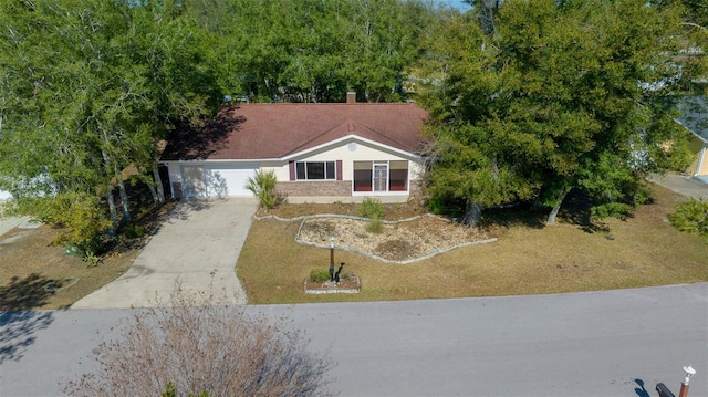 view of front facade with an attached garage, brick siding, and driveway