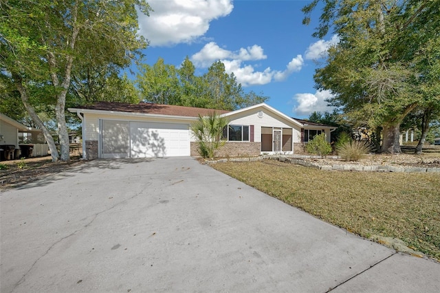 single story home featuring brick siding, driveway, an attached garage, and a front yard