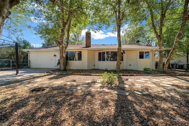 ranch-style home with fence and a chimney