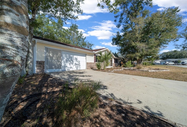 view of front facade featuring brick siding, driveway, and a garage