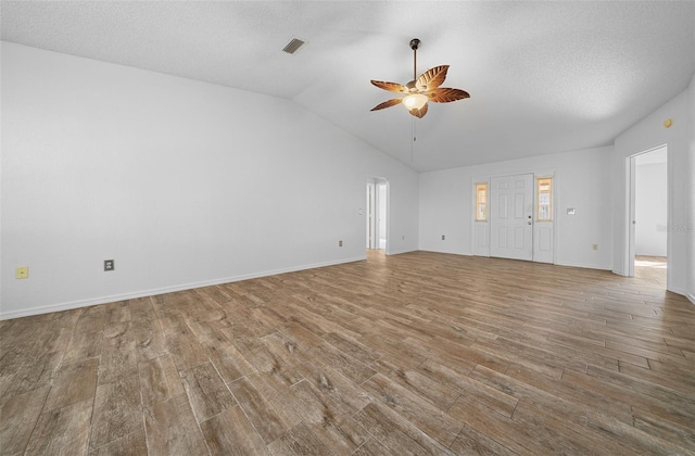 unfurnished living room featuring visible vents, a textured ceiling, wood finished floors, ceiling fan, and vaulted ceiling