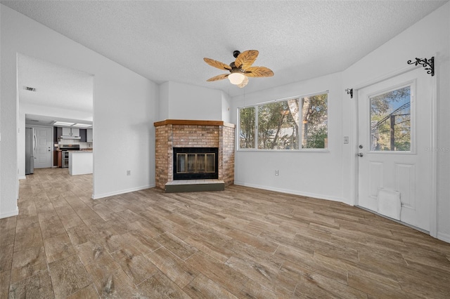 unfurnished living room featuring plenty of natural light, light wood-type flooring, and ceiling fan