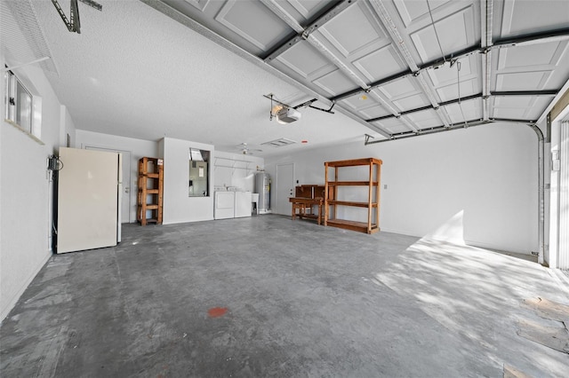 garage with washing machine and clothes dryer, water heater, electric panel, freestanding refrigerator, and a garage door opener