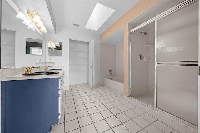 bathroom featuring tile patterned floors, a stall shower, a sink, a skylight, and a bath