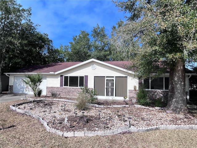 ranch-style house with concrete driveway, a garage, and brick siding