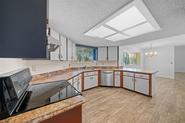 kitchen with a peninsula, black range with electric cooktop, under cabinet range hood, dishwasher, and a chandelier