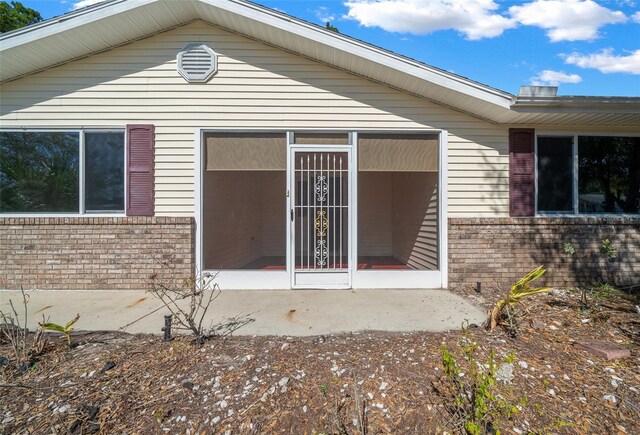 doorway to property featuring brick siding