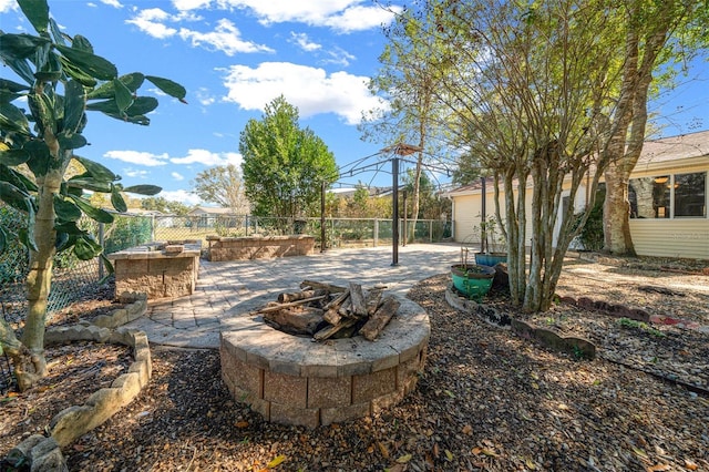 view of yard featuring a patio area, fence, and an outdoor fire pit