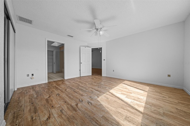 unfurnished bedroom featuring visible vents, wood finished floors, a closet, and a textured ceiling