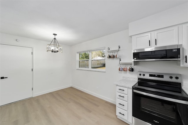 kitchen with white cabinetry, hanging light fixtures, light stone counters, stainless steel appliances, and light hardwood / wood-style flooring