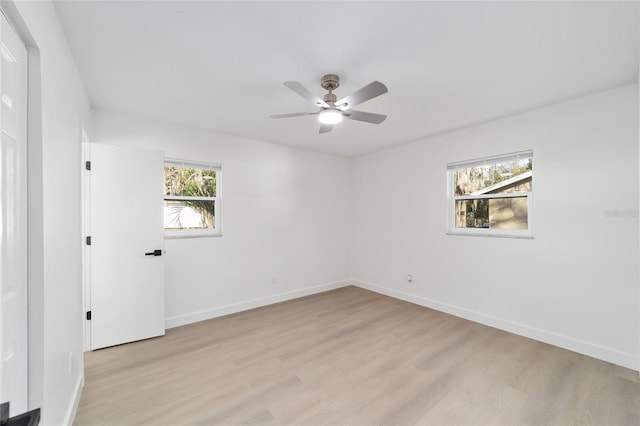 unfurnished room featuring ceiling fan, light hardwood / wood-style floors, and a wealth of natural light