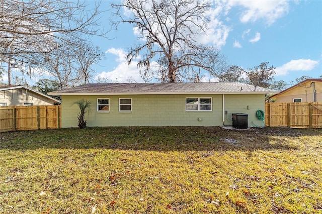 rear view of property featuring a yard and central air condition unit