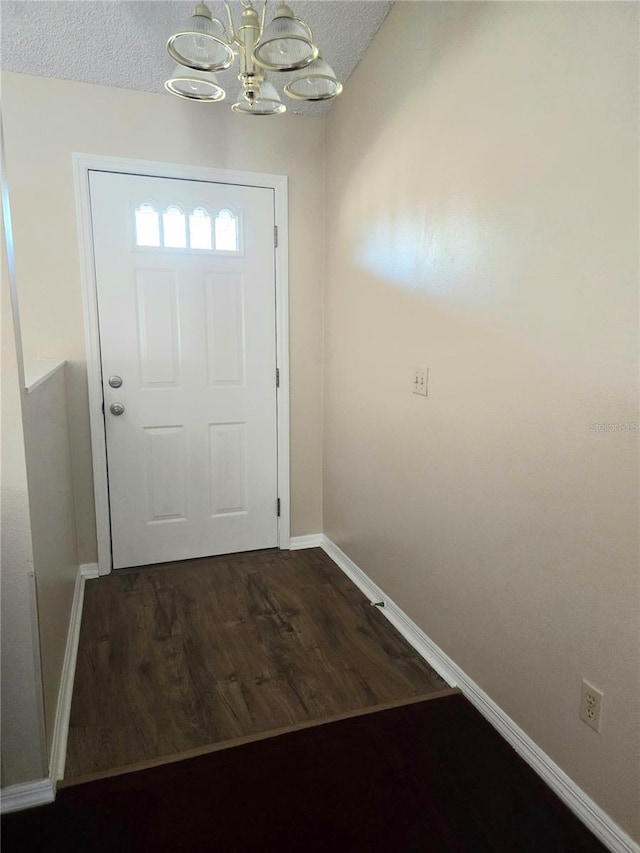 doorway featuring dark hardwood / wood-style floors and a notable chandelier