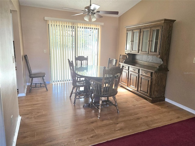 dining area featuring ceiling fan, vaulted ceiling, light hardwood / wood-style flooring, and a textured ceiling